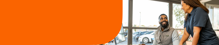 Man and woman at a desk inside a car dealership