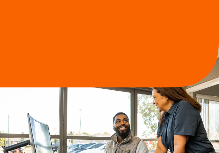 Man and woman at a desk inside a car dealership